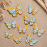 Butterfly-shaped cookies with blue and gold design on a beige background