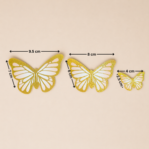 Three gold butterfly decorations with measurements on a beige background