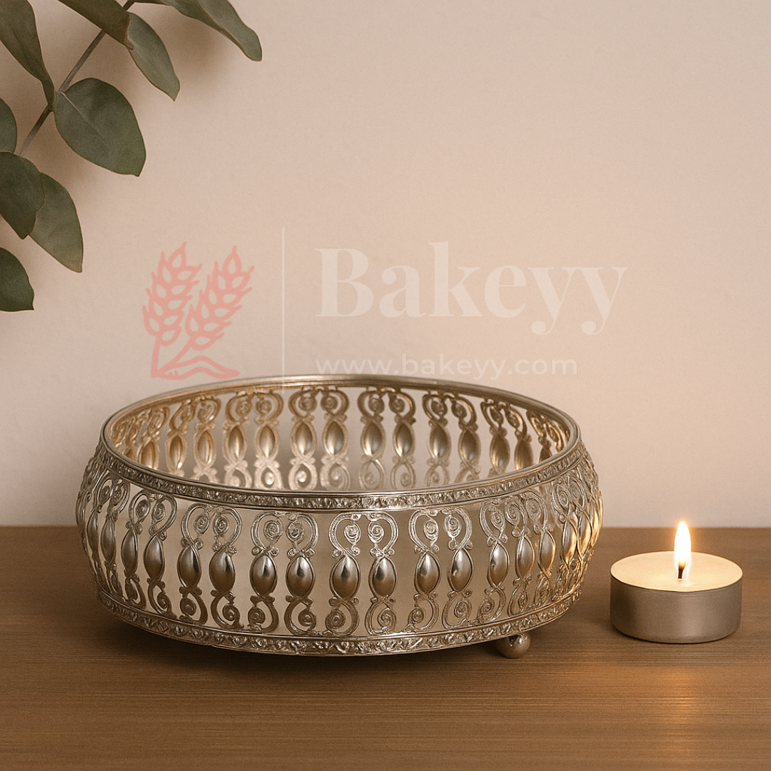 Decorative metal bowl with intricate patterns on a wooden surface next to a lit candle, with 'Bakeyy' branding.