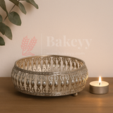 Decorative metal bowl with intricate patterns on a wooden surface next to a lit candle, with 'Bakeyy' branding.