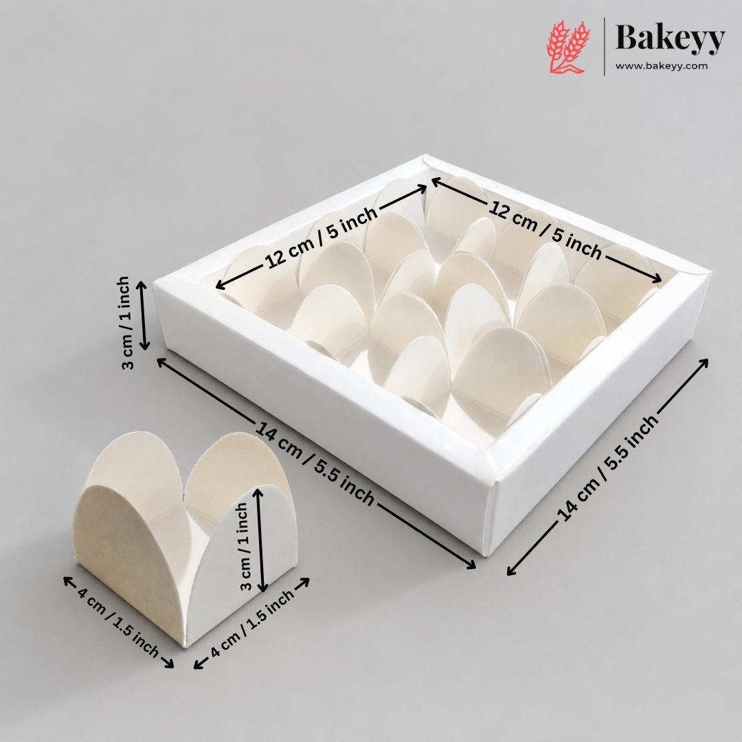 White square bakery box with multiple heart-shaped paper insert compartments, shown with dimension arrows and labels indicating 14 cm by 12 cm by 3 cm measurements on a light gray background. A smaller standalone heart-shaped insert is shown in front, and the Bakeyy logo appears in the top right.