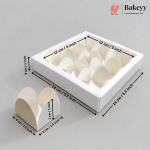 White square bakery box with multiple heart-shaped paper insert compartments, shown with dimension arrows and labels indicating 14 cm by 12 cm by 3 cm measurements on a light gray background. A smaller standalone heart-shaped insert is shown in front, and the Bakeyy logo appears in the top right.