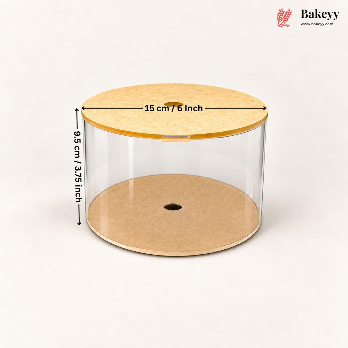 Clear cylindrical cake or pastry display container with a light wood lid and base, shown on a white background with dimension arrows indicating 15 cm / 6 inch diameter and 9.5 cm / 3.