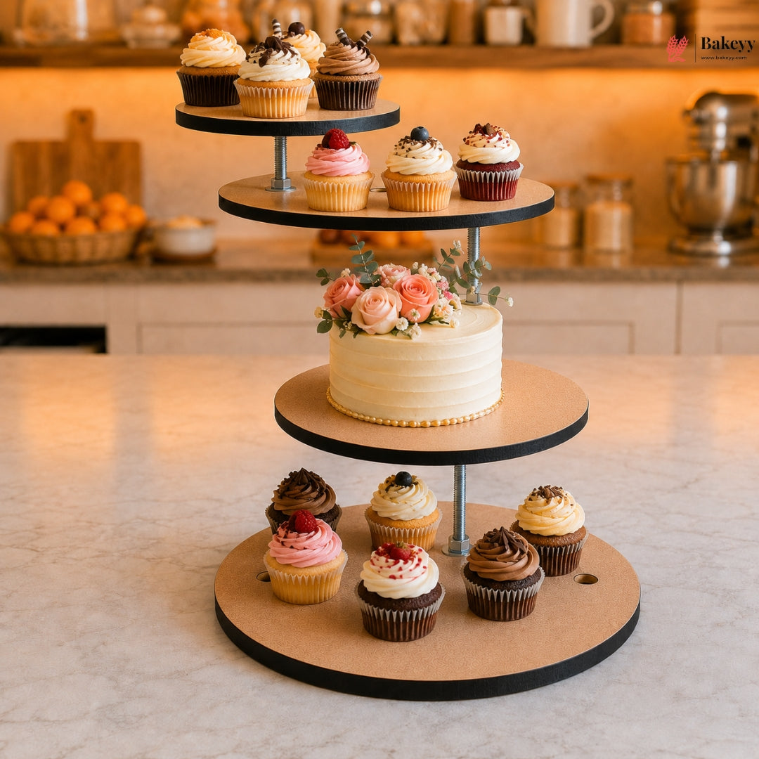 Three-tiered cake stand with a cake and cupcakes on a kitchen counter.