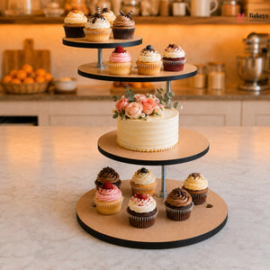 Three-tiered cake stand with a cake and cupcakes on a kitchen counter.