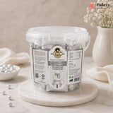 Clear container of silver sugar paste with a label on a marble surface, featuring the Bakey brand.