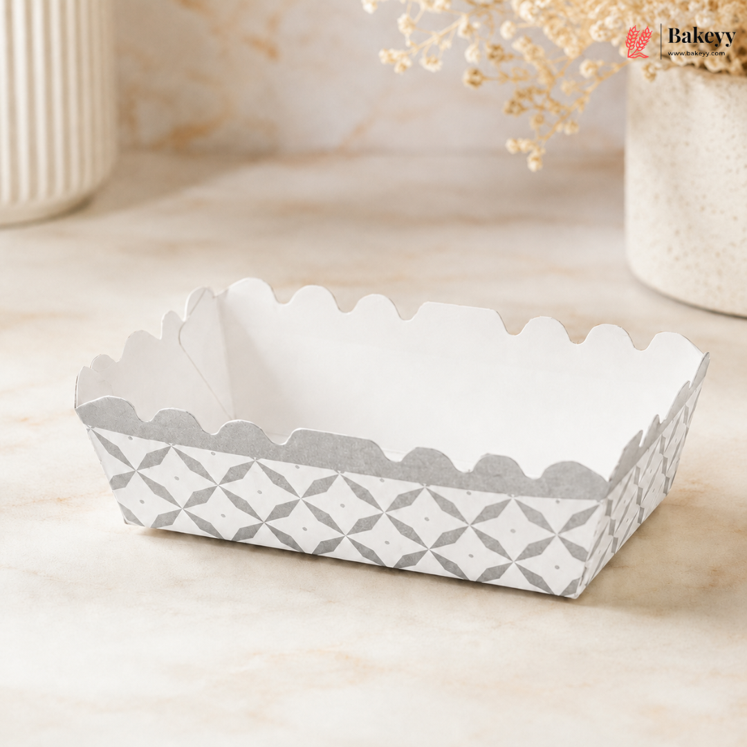 White paper food container with geometric pattern on a beige surface, featuring the brand 'Bakey'.