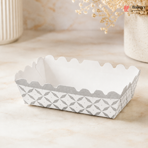 White paper food container with geometric pattern on a beige surface, featuring the brand 'Bakey'.