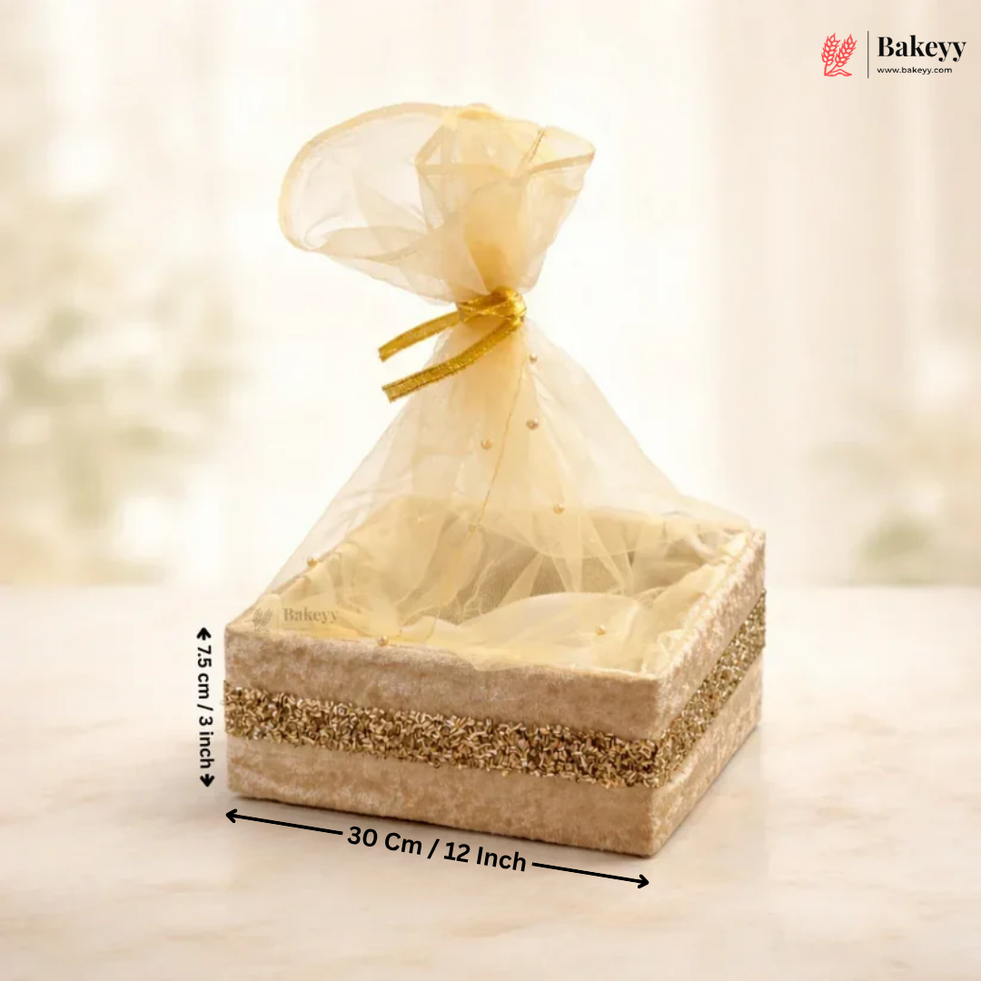 Bakery gift box with sheer gold cover and measurements on a soft background