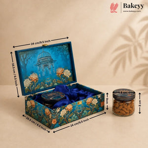 An ornate blue decorative gift box with floral artwork and a matching round tin inside, shown open with dimension arrows indicating measurements. A small jar of almonds sits beside it on a beige background with shadow overlays.