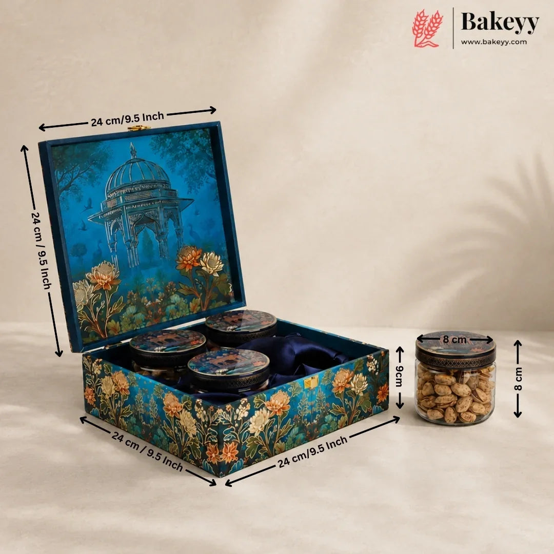 Decorative blue gift box with floral artwork and an open lid showing three round jars, alongside a smaller jar of nuts with dimension arrows and labels. Bakeyy branding appears in the top right.