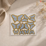 Butterfly-shaped stickers on a beige surface with a natural background