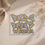 Butterfly-shaped stickers on a beige surface with a natural background