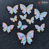 A set of iridescent butterfly-shaped baking cookies or sugar cookies arranged on a dark textured background, with a Bakeey brand logo in the top right corner.