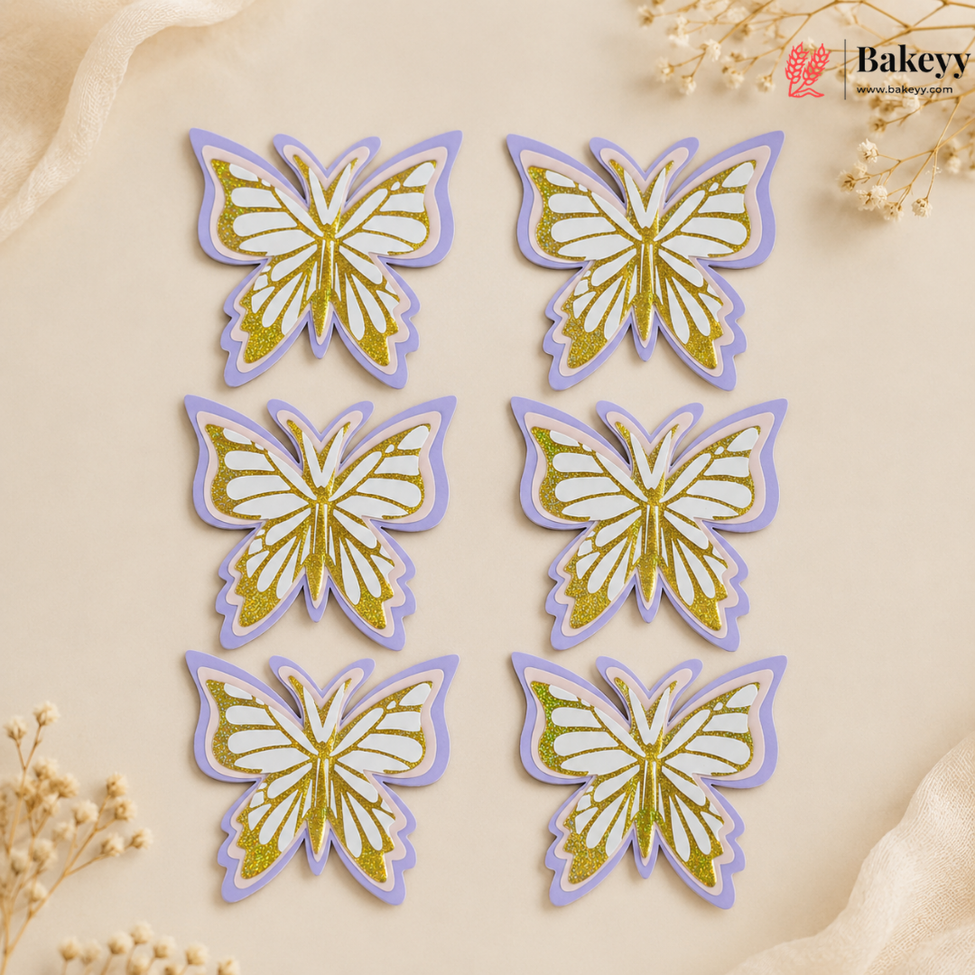 Six butterfly-shaped decorations with gold and purple details on a beige background, branded 'Bakeyy'.