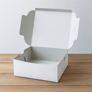 White bakery cake box with open lid on wooden table, ideal for Bakeyy gift packaging.