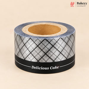 A roll of decorative washi tape with a black and white argyle pattern, featuring a black band at the bottom with the text 'Delicious Cake' and a white logo. The tape is shown on a neutral beige background with a Bakeyy brand logo in the top right corner.