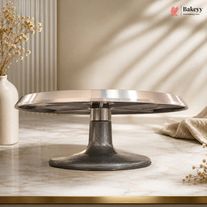 Metallic cake stand on a marble surface with a neutral background