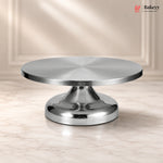 Metallic cake stand on a beige background with 'Bakeyy' branding.