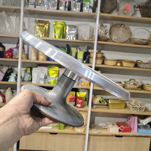 Metallic kitchen tool held in front of a store shelf with various products.
