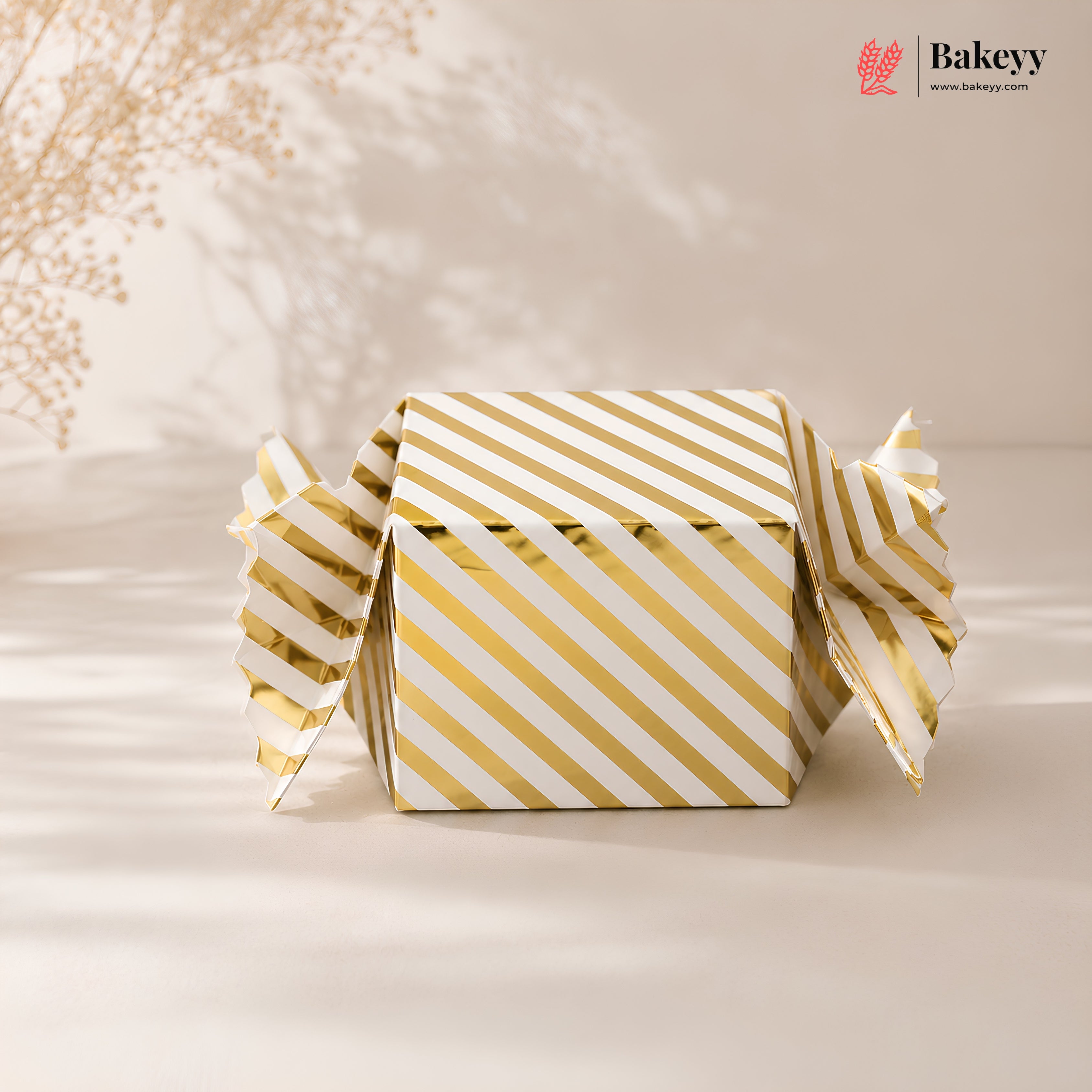 Gold and white striped box with 'Bakeyy' branding on a beige background