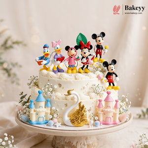 Decorative cake with cartoon character figurines and castle decorations on a stand.