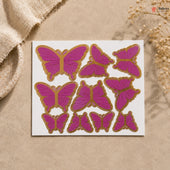 Butterfly-shaped stickers with pink and gold design on a beige surface