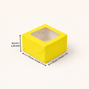 A bright yellow square paper box with a clear window on top, shown on a light beige background with black dimension arrows and text indicating 7.5 cm / 3 inch by 7.