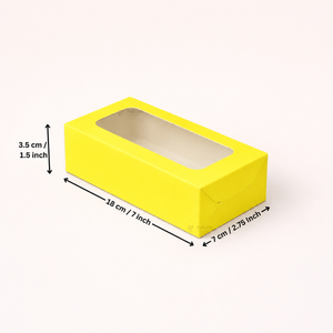 A bright yellow rectangular display box with a clear window on top, shown on a light beige background with dimension arrows and labels indicating 18 cm length, 7 cm width, and 3.5 cm height.