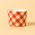Red and white checkered cupcake wrapper on a beige background