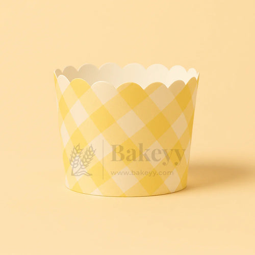 Yellow and white checkered cupcake wrapper with 'Bakeyy' branding on a beige background