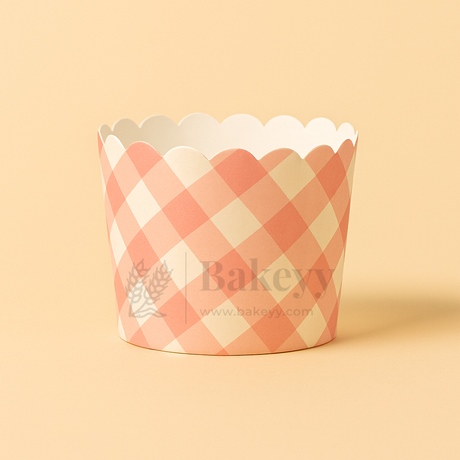 Checkered cupcake wrapper with scalloped edge on a beige background