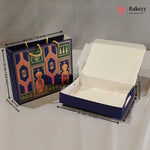 A navy blue bakery gift bag and matching open cardboard box with printed ornate arch motifs, shown on a white surface with dimension arrows and labels. The Bakeyy logo appears in the top right.