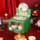 Christmas-themed display stand with snowman design and cupcakes on a red background