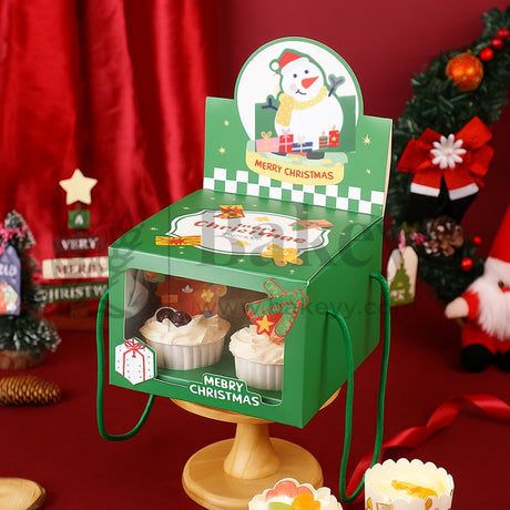 Christmas-themed display stand with snowman design and cupcakes on a red background