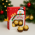 Christmas-themed chocolate box with gold chocolates and a snowman design, set against a festive background.
