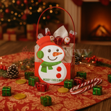 Christmas-themed gift bag with snowman design on a festive table with candy and decorations.