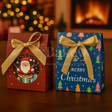 Two Christmas-themed gift boxes with Santa Claus and colorful trees on a wooden surface.