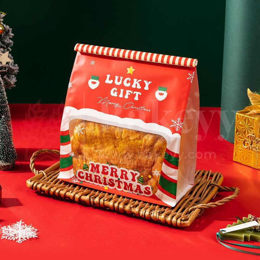 Red 'Lucky Gift' Christmas bag with a treat on a red surface with festive decorations.