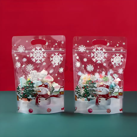 Two Christmas-themed clear bags with snowflakes and snowmen on a red and blue gradient background.