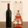 Wine bottle with red cap next to a decorative wine bag with Christmas tree design on a beige background.