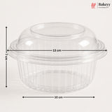 Clear plastic dome lid with a flared rim and ribbed base, shown with dimension arrows and labels indicating 13 cm width, 10 cm base diameter, and 7 cm height on a light gray background. Bakeyy logo appears in the top right.