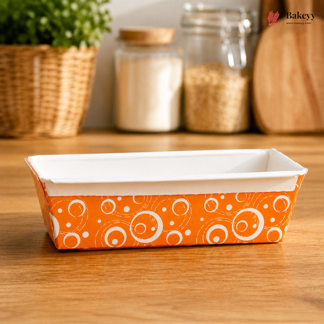 Rectangular baking dish with orange and white pattern on a wooden surface, branded 'Bakeyy'.
