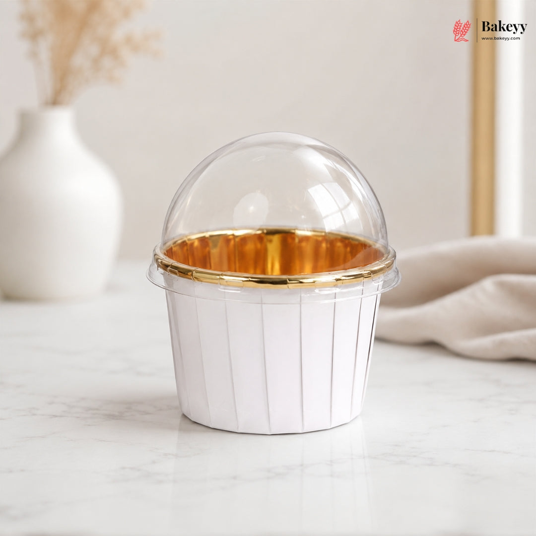 Clear plastic cupcake holder with gold interior on a marble surface, branded 'Bakey'.