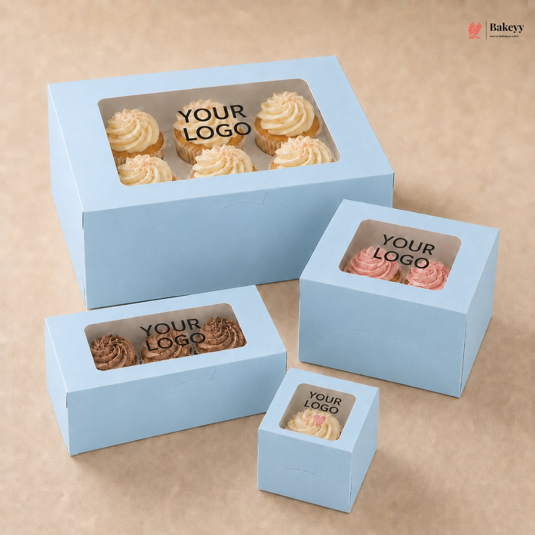 Set of light blue cake boxes with windowed tops on a beige background