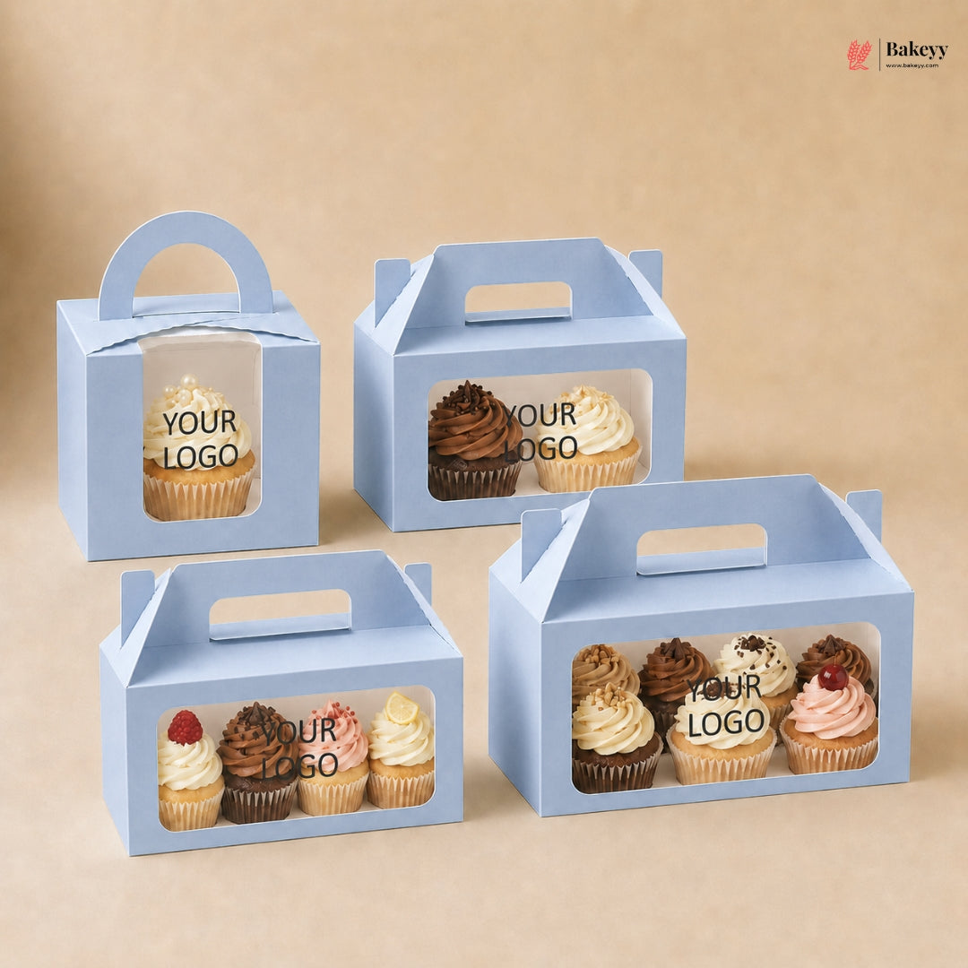 Set of four blue cupcake boxes with window panels displaying cupcakes and 'Your Logo' text on a beige background.