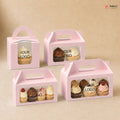 Pink cupcake boxes with window on a beige background, featuring various cupcakes and 'Your Logo' text.