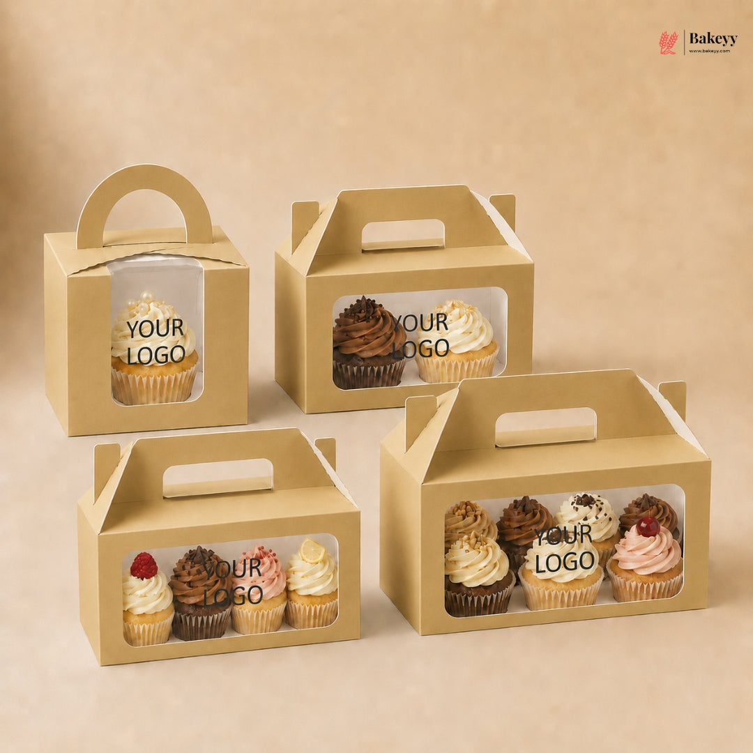 Four cardboard cupcake boxes with clear windows displaying cupcakes, on a beige background.