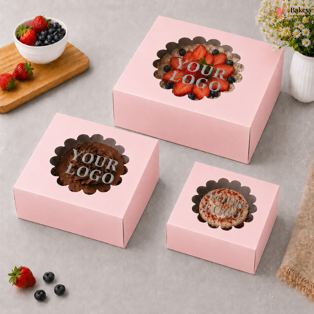 Pink cake boxes with 'Your Logo' text on a gray surface with berries and flowers.