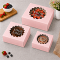 Pink cake boxes with 'Your Logo' text on a gray surface with berries and flowers.
